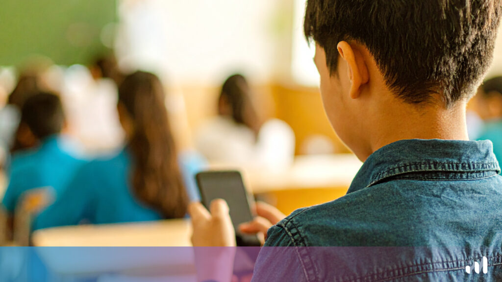 enfant qui regarde son téléphone en classe
