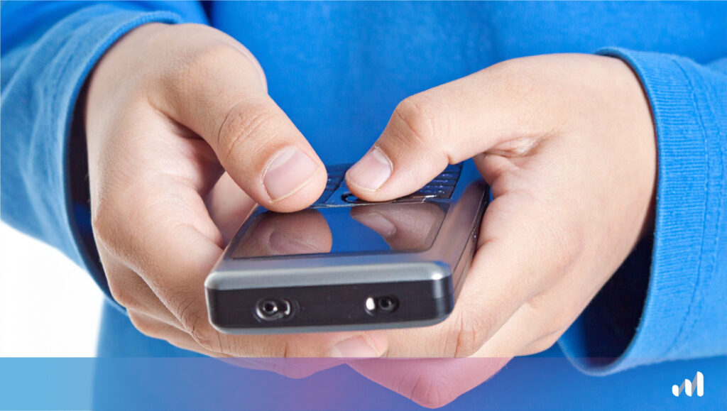 enfant qui tient un dumb phone dans les mains