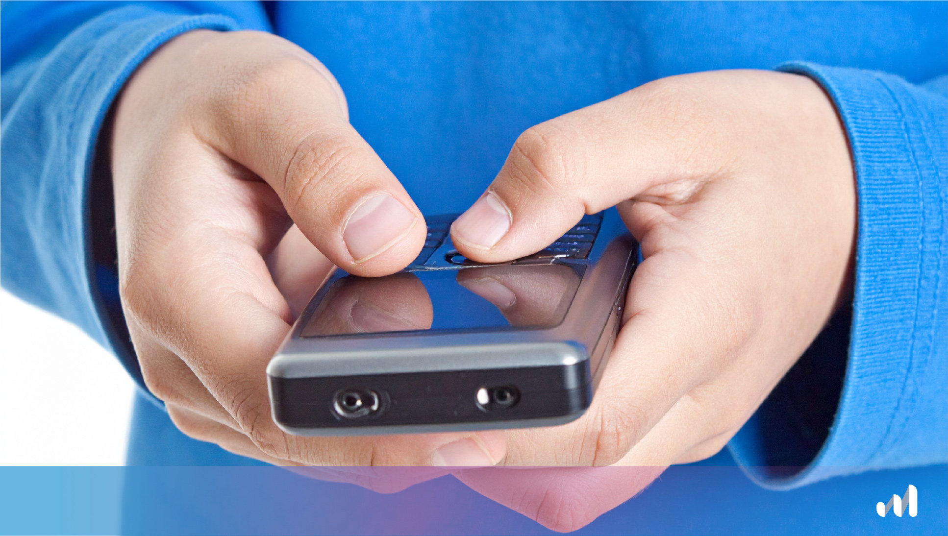 enfant qui tient un dumb phone dans les mains