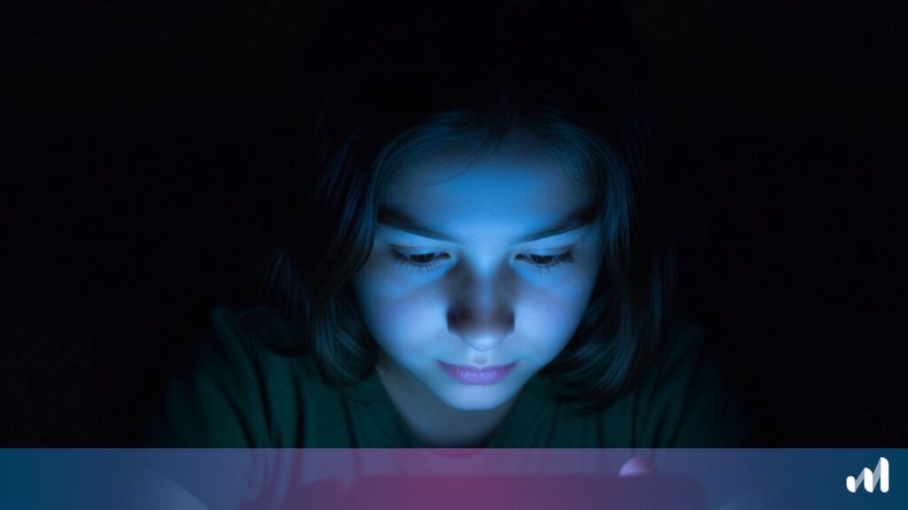 un enfant au visage éclairé par un smartphone